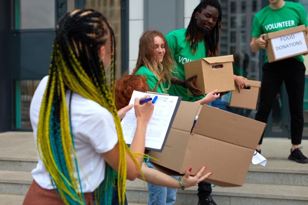 Auf dem Foto sind Volunteers zu sehen, die Lebensmittel verteilen.