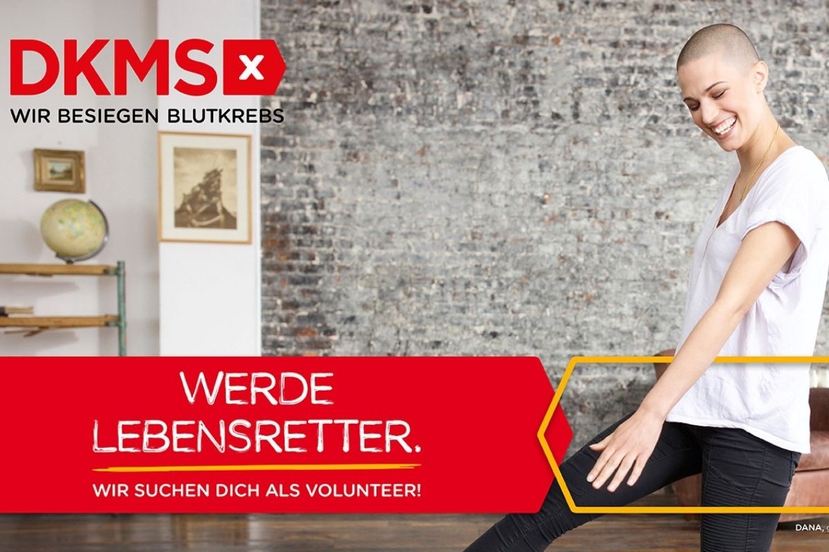 Auf dem Foto ist ein Plakat der DKMS zu sehen. Links oben im Bild befindet sich das Logo. Rechts ist eine Frau mit Glatze zu sehen. Sie ist gut gelaunt, tanzt und lacht.