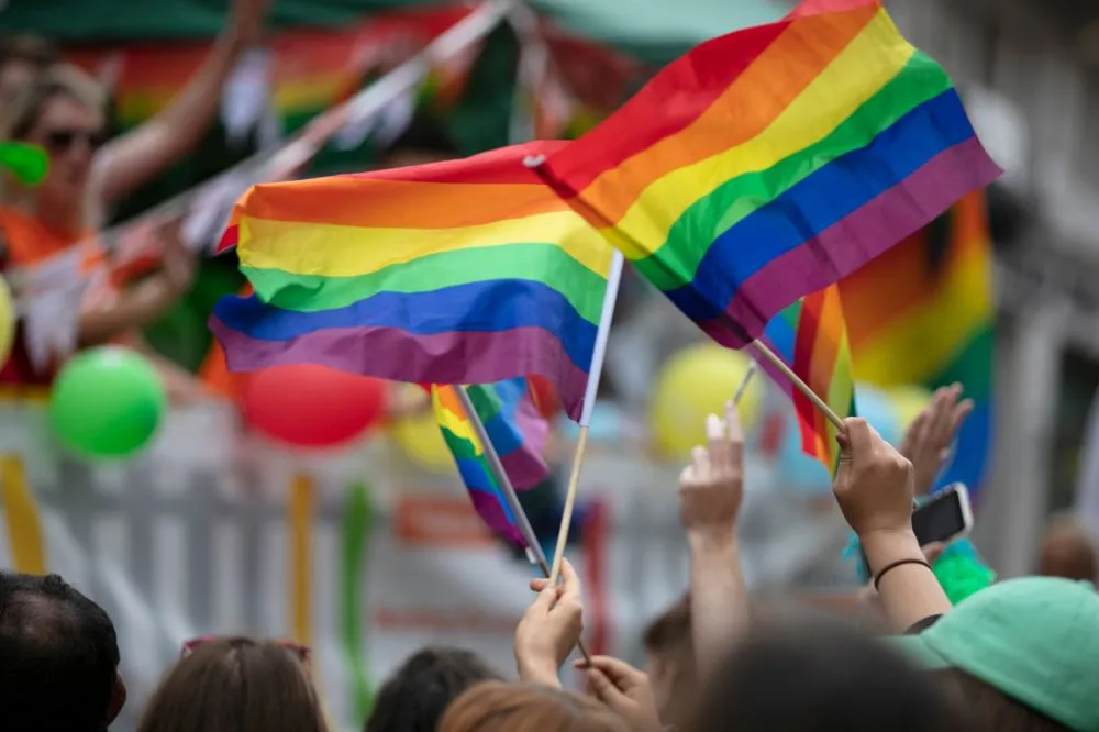 Auf dem Foto sind Fahnen in Regenbogenfarben zu sehen. Auch Du kannst jetzt die LGBTQIA+ Community unterstützen.