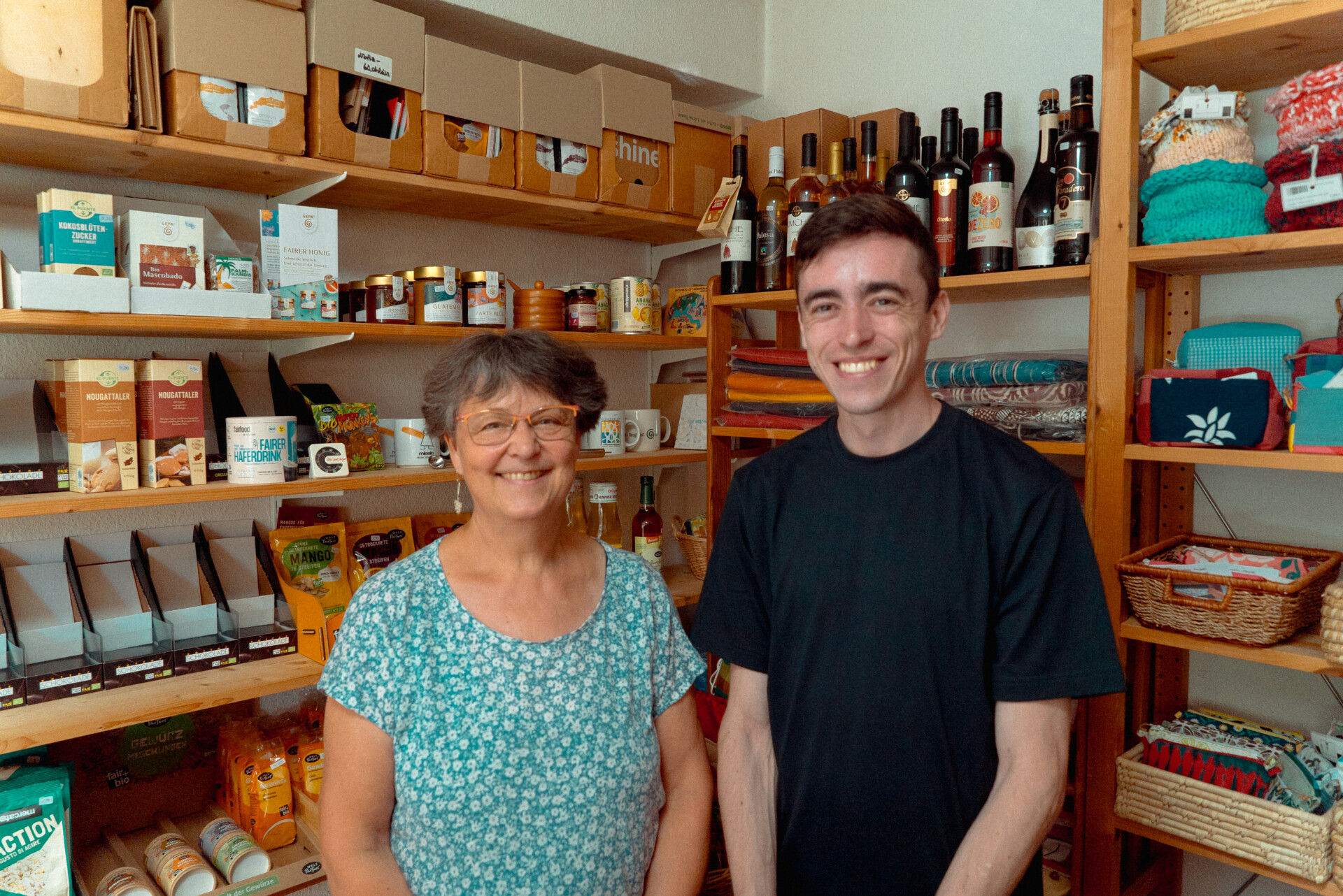 Illia und seine Ehrenamtsbetreuerin Manuela stehen vor den Regalen des Weltladens Teltow.