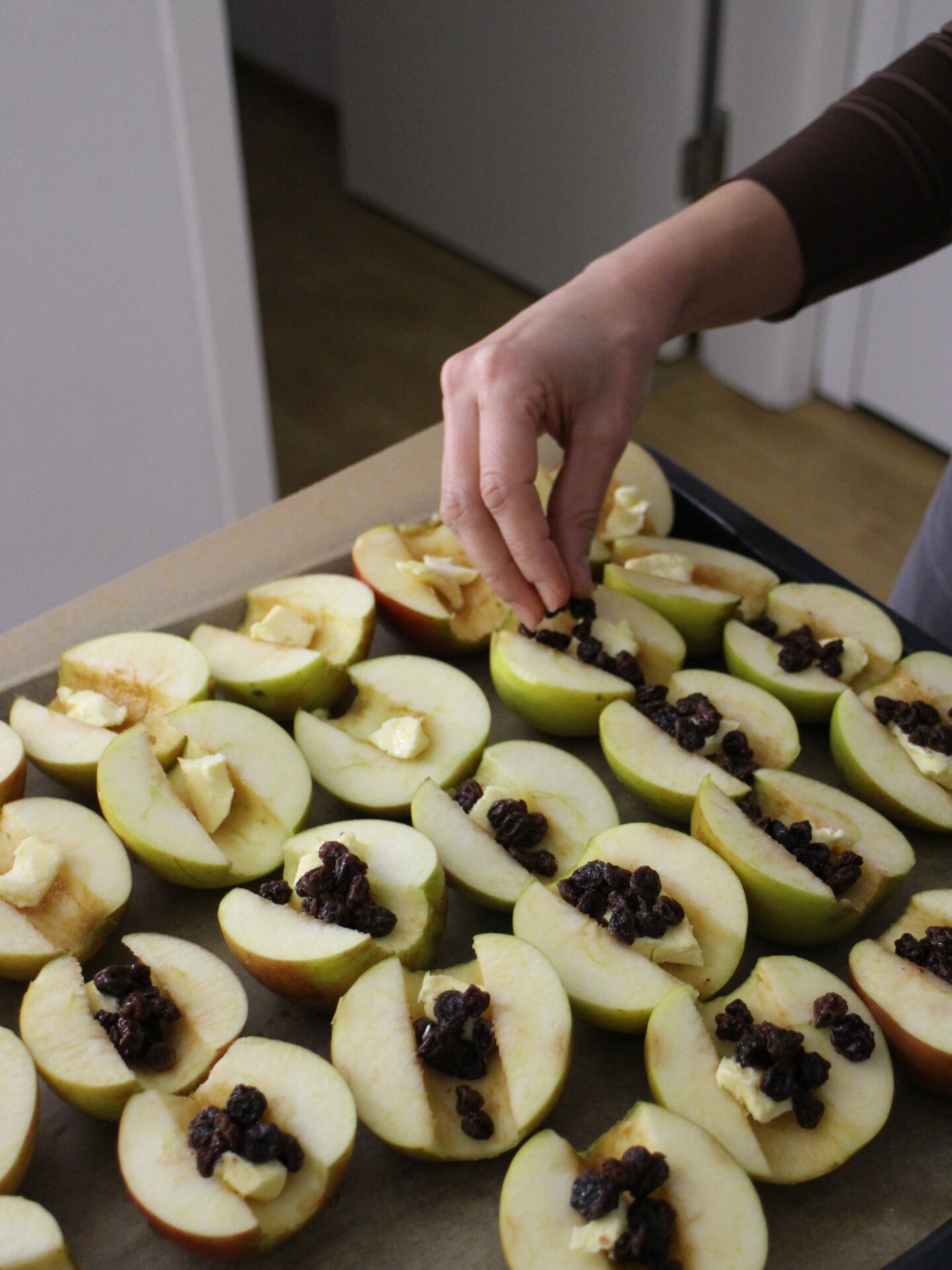 Burcu-Dessert-Volunteer-Story-Du-Fuer-Berlin-GoVolunteer Gefüllte Äpfel auf einem Backblech mit Butter und Rosinen.